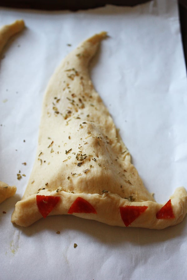 The calzone shaped into a witch hat with the seasoning and pepperoni on top.