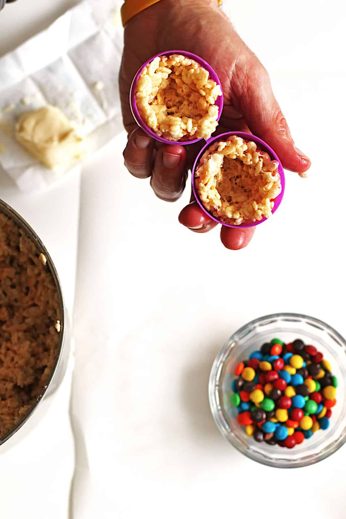 Rice Krispie treats on each side of a plastic egg before placing the M&M candy inside