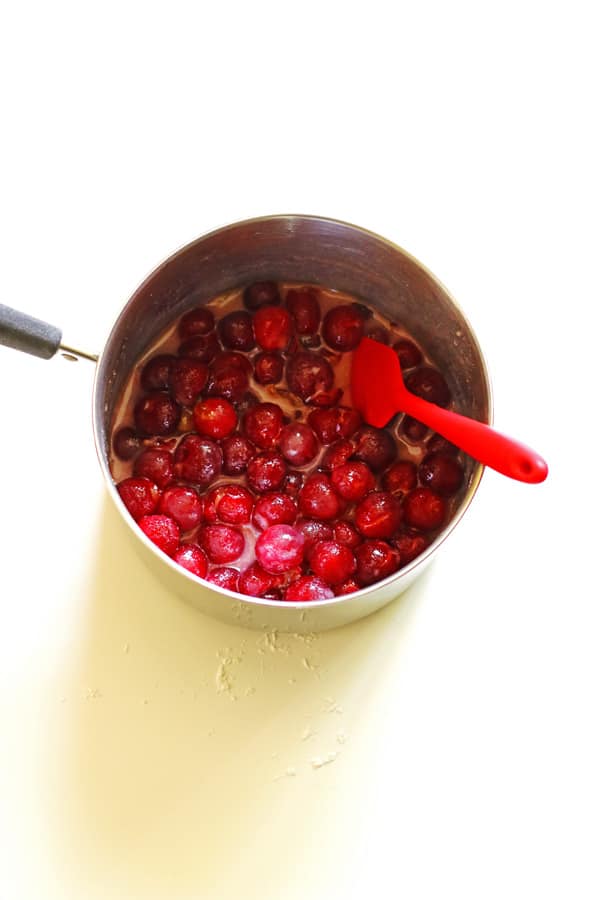 Cherries coated in sugar in saucepan