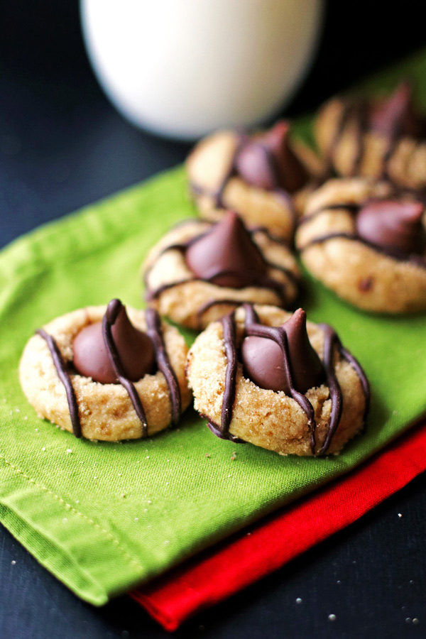 Peanut Butter Kiss Cookies drizzled with melted chocolate on green and red napkins
