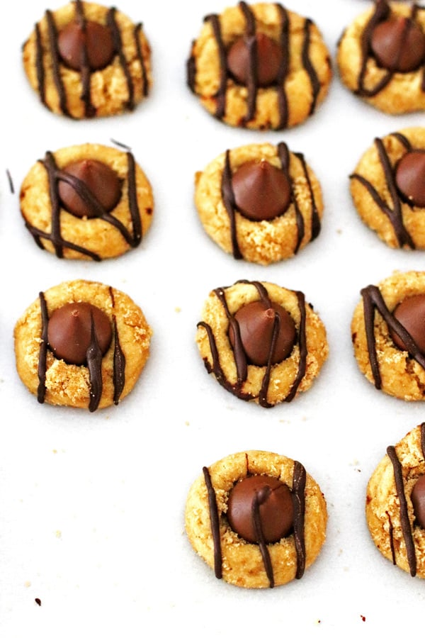 Cookies drizzled with chocolate on white parchment paper