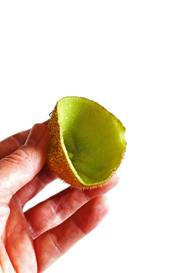 Hand holding the skin of a kiwi