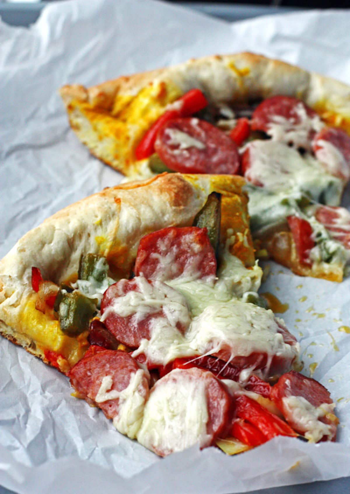 Pizza night just got a new twist! This Supreme Pizza is topped with peppers, onion, Polish sausage and two cheeses. Perfect for watching the game or a fun pizza for family pizza night. #pizzarecipe #pizza #polishsausage #dinnerrecipe