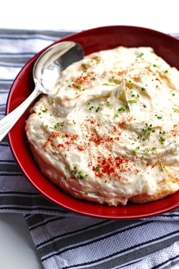 Mashed potatoes in a red bowl with a spoon