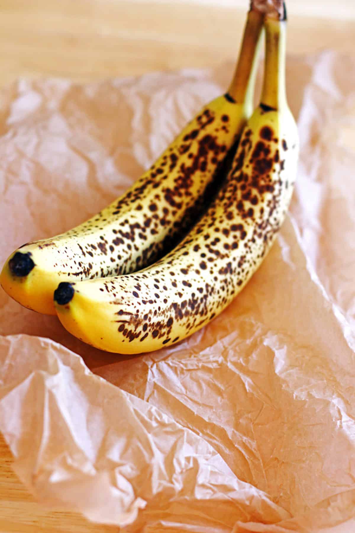 Ripened bananas sitting on brown parchment paper