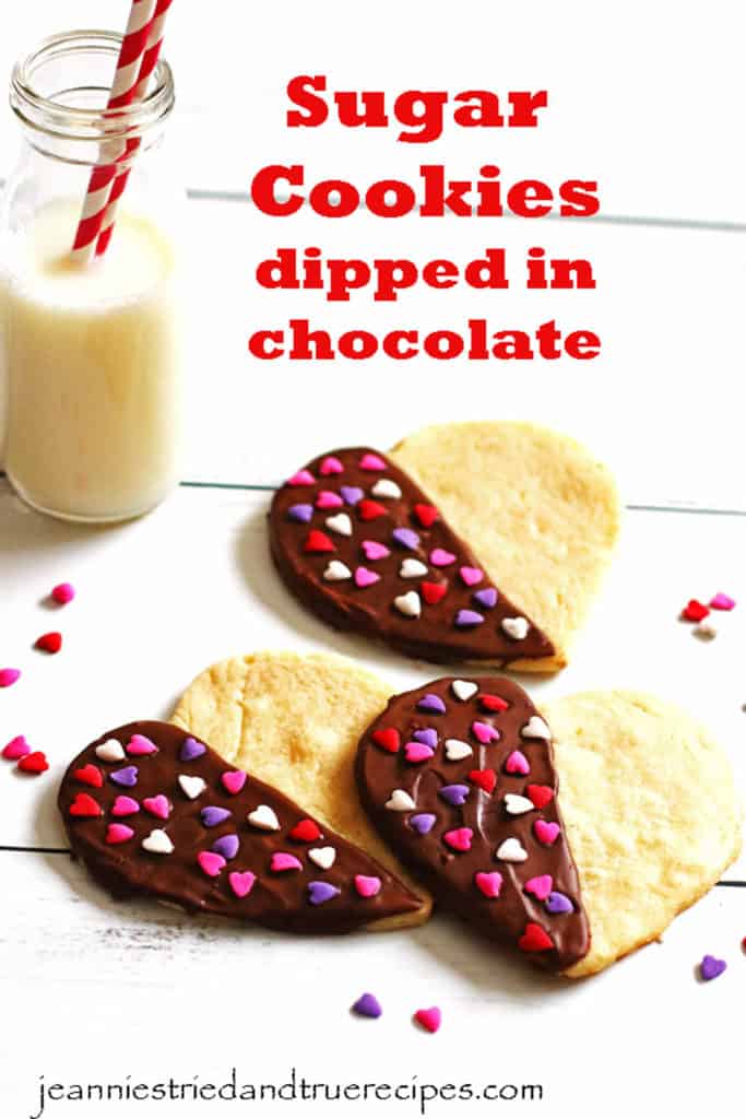 Sugar Cookies in the shape of hearts are dipped in chocolate and covered with heart shaped sprinkles.