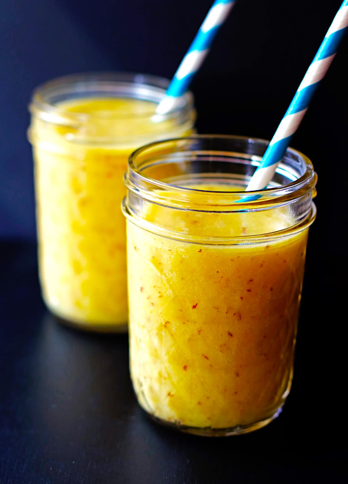 Two jars of pineapple mango and banana smoothie.