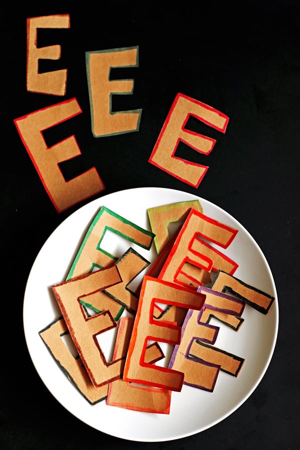 Several capital letter E's cut out from brown paper on a white plate. They are part of an April Fools Day joke.