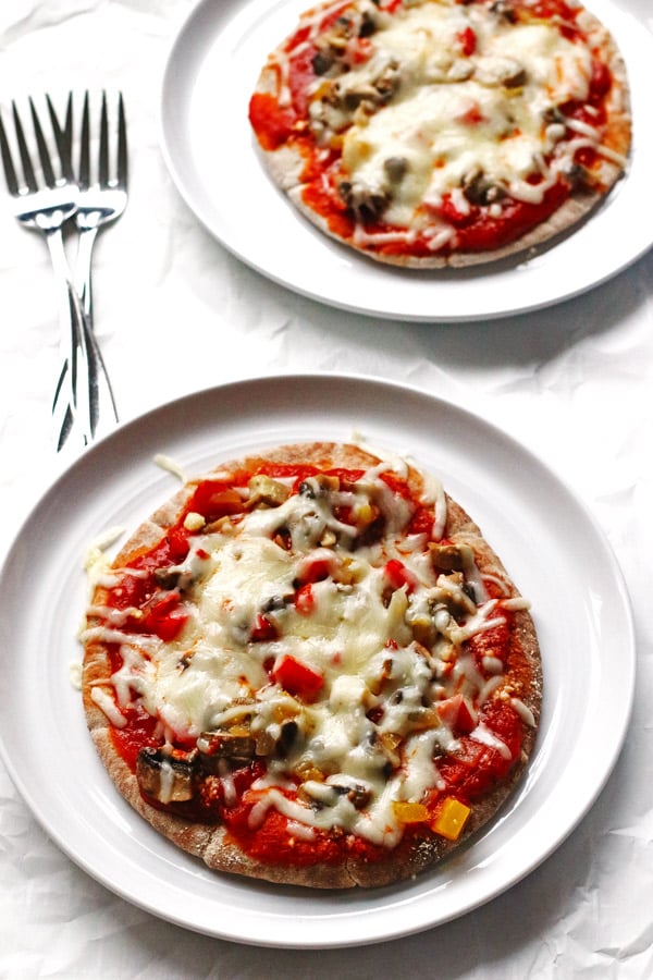 This recipe for Veggie Pita Pizzas are made on whole wheat pitas and covered with peppers, onions, mushrooms and cheese.