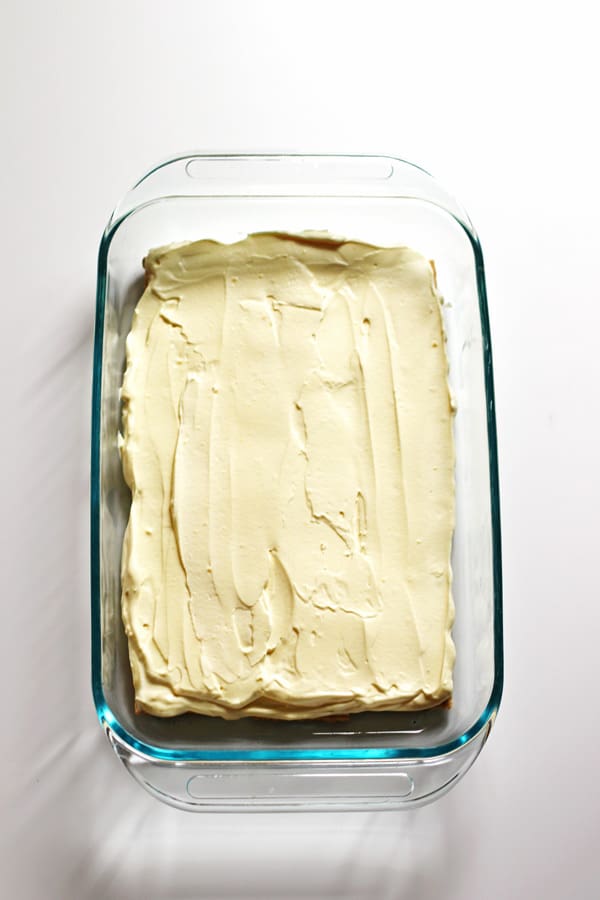 Vanilla Pudding mixture spread evenly over graham crackers in clear baking dish