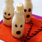Vanilla milkshakes that are in a clear glass and decorated as ghosts