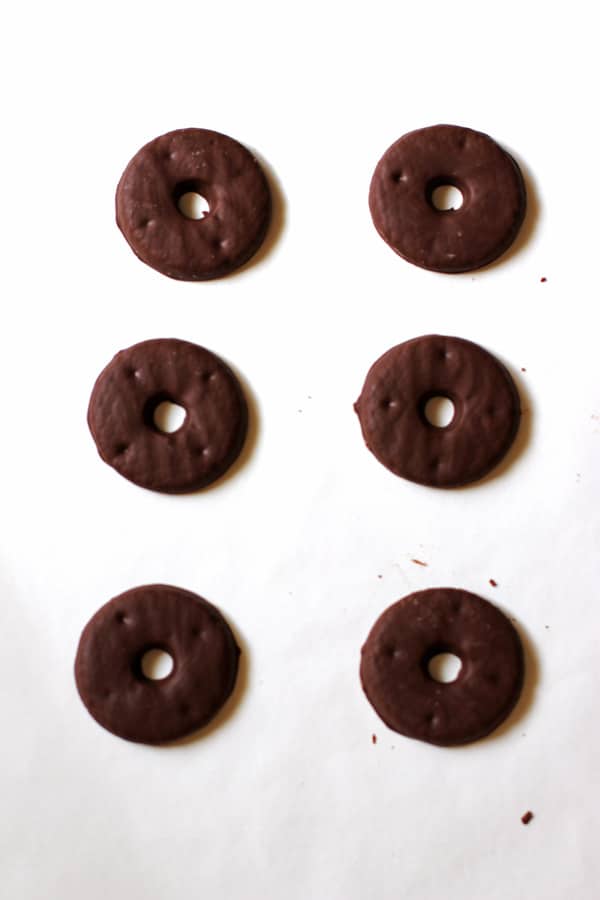 Chocolate covered cookies in a single layer on parchment paper