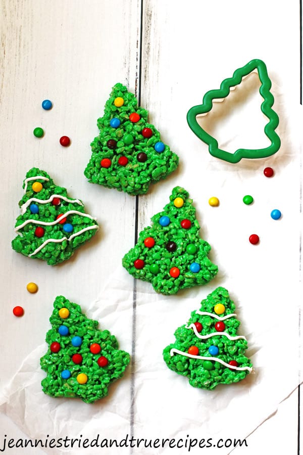 Green Rice Krispie Trees decorated with M&M candy and white icing.