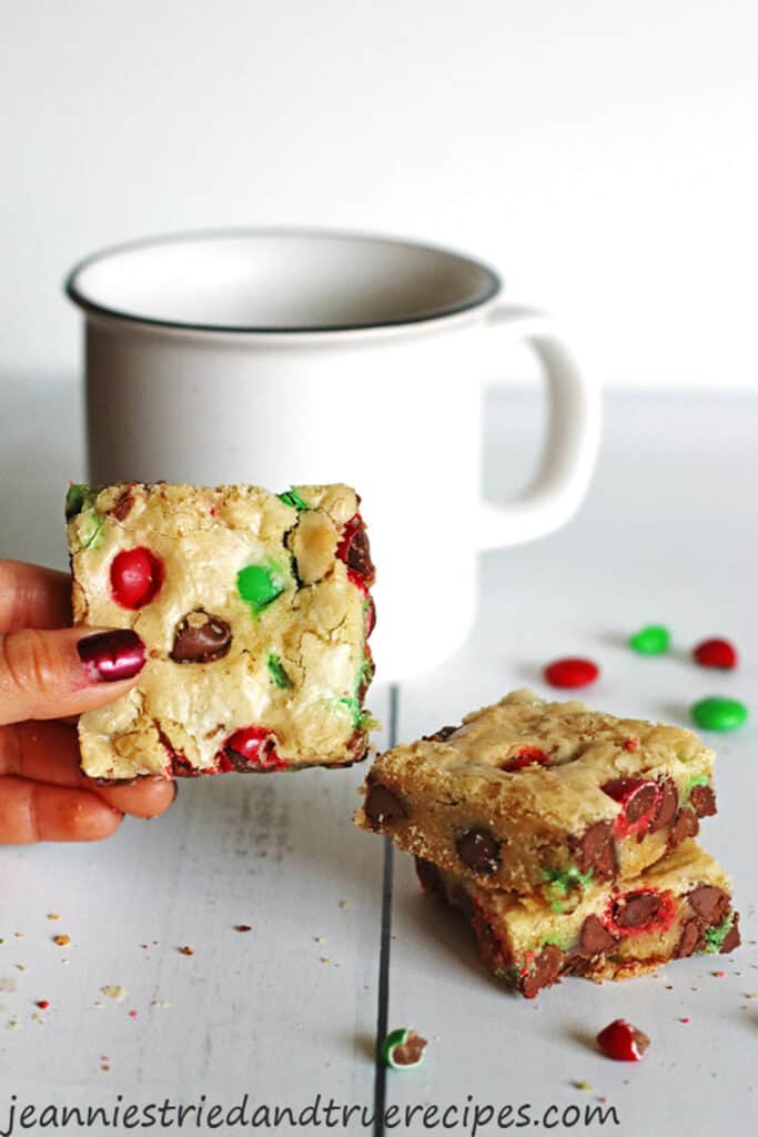 Cookie Bars on table next to a white mug