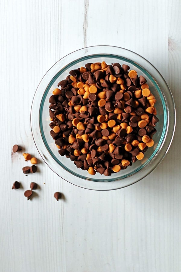Butterscotch and chocolate chips mixed together in a clear mixing bowl