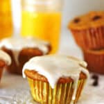 Muffins on a white table with a glass of orange juice