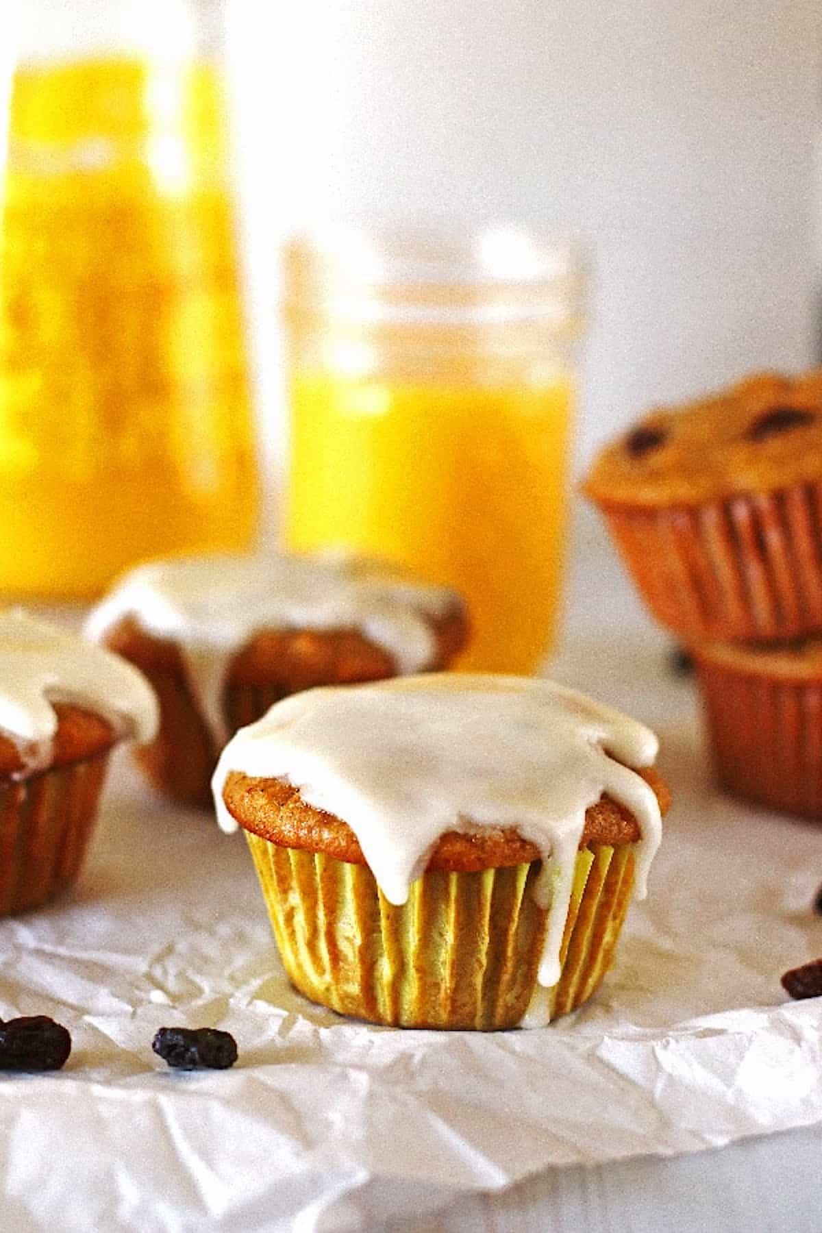Muffins on a table with a glass of orange juice