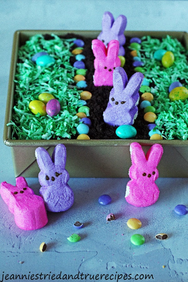Dirt Cake decorated with bunny Peeps, candy eggs and coconut colored green for grass