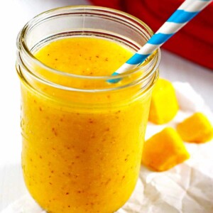 A smoothie made from pineapple, mango and banana in a canning jar