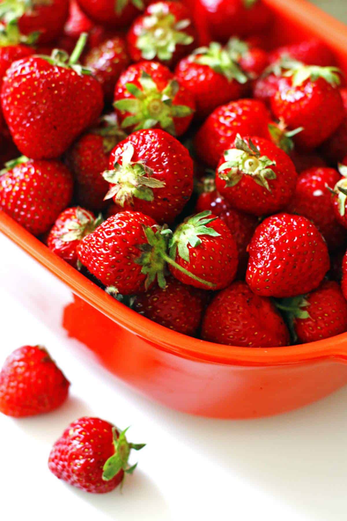 A bowl of fresh strawberries for crumble bars.