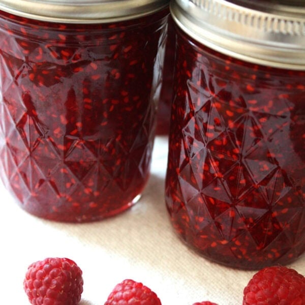Two jars of homemade raspberry freezer jam.