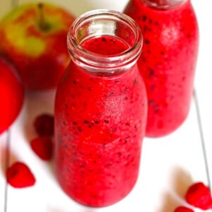 Two jars of a healthy apple berry smoothie.