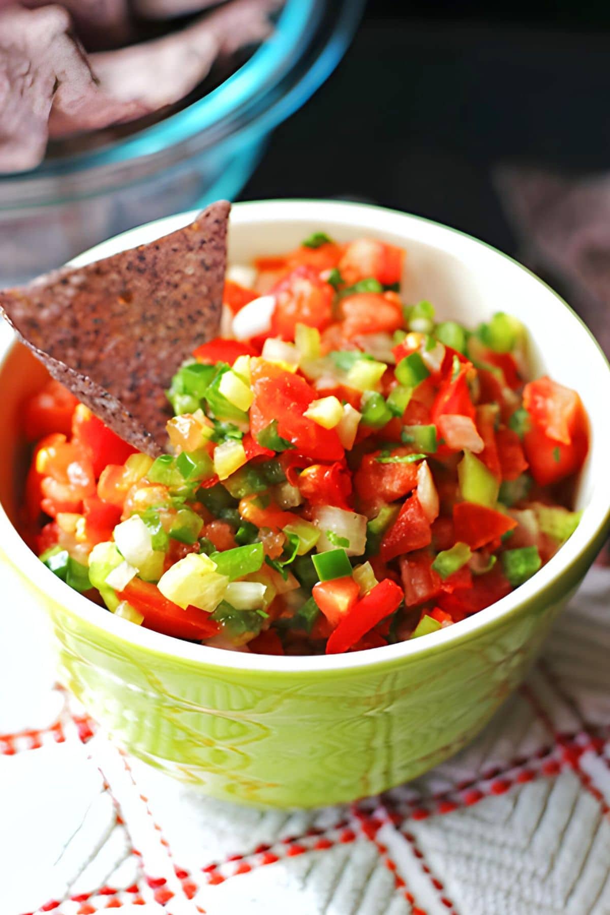 A green bowl of salsa fresca with diced tomatoes and cilantro.