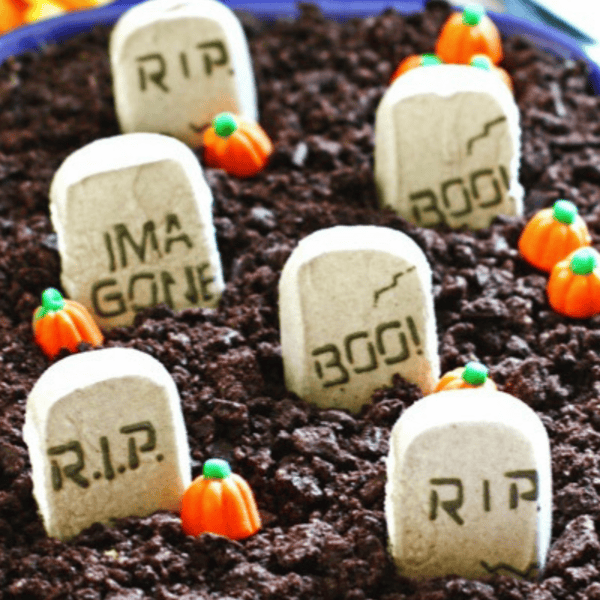 Halloween dirt cake - vanilla pudding covered with crushed up Oreo cookies covered with pumpkin and tombstone edible decorations.