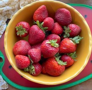 A bowl of strawberries ready to freeze for smoothies and jam.