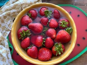 A yellow bowl of fresh strawberries.