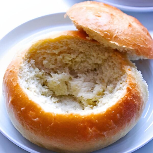 A hollowed out bread bowl on a white plate.