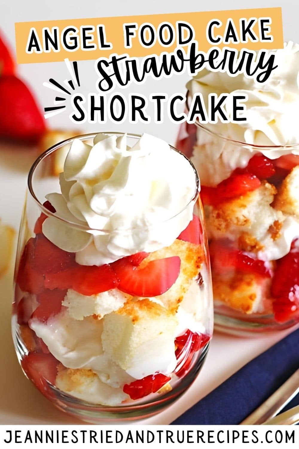 A pin image of strawberry shortcake angel food cake in wine glasses with whipped cream on top.