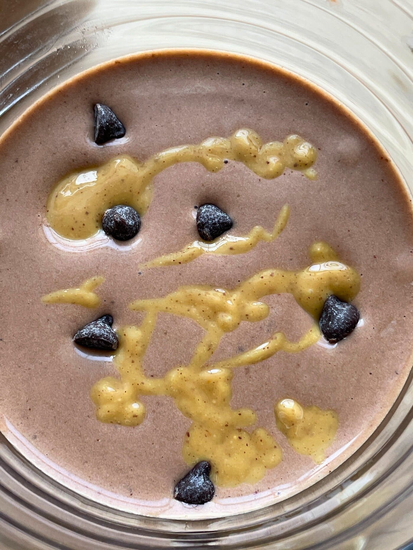 A banana chocolate peanut butter smoothie with peanut butter drizzled over the top.