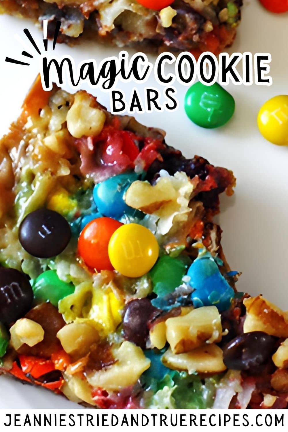 A pin image a seven layer bar with nuts, coconut, chocolate chips, and mini m and ms on a white plate with a bite taken out of it.