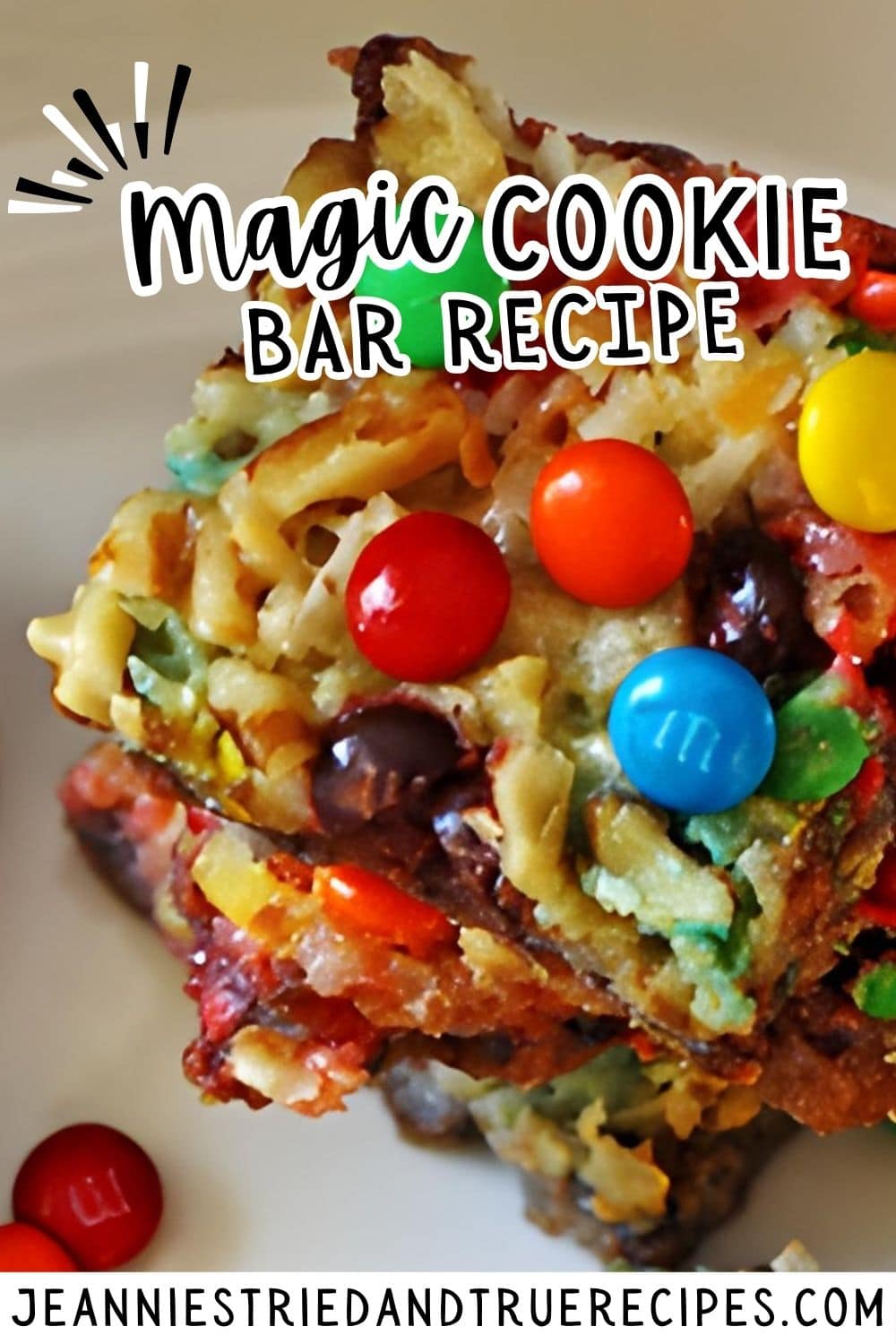 A pin image of magic cookie bars with nuts, coconut, chocolate chips, and mini m and ms stacked on a white plate from the top.