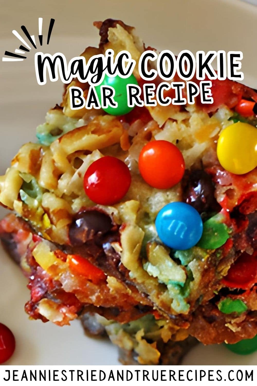 A pin image of seven layer bars with nuts, coconut, chocolate chips, and mini m and ms stacked on a white plate from the top.