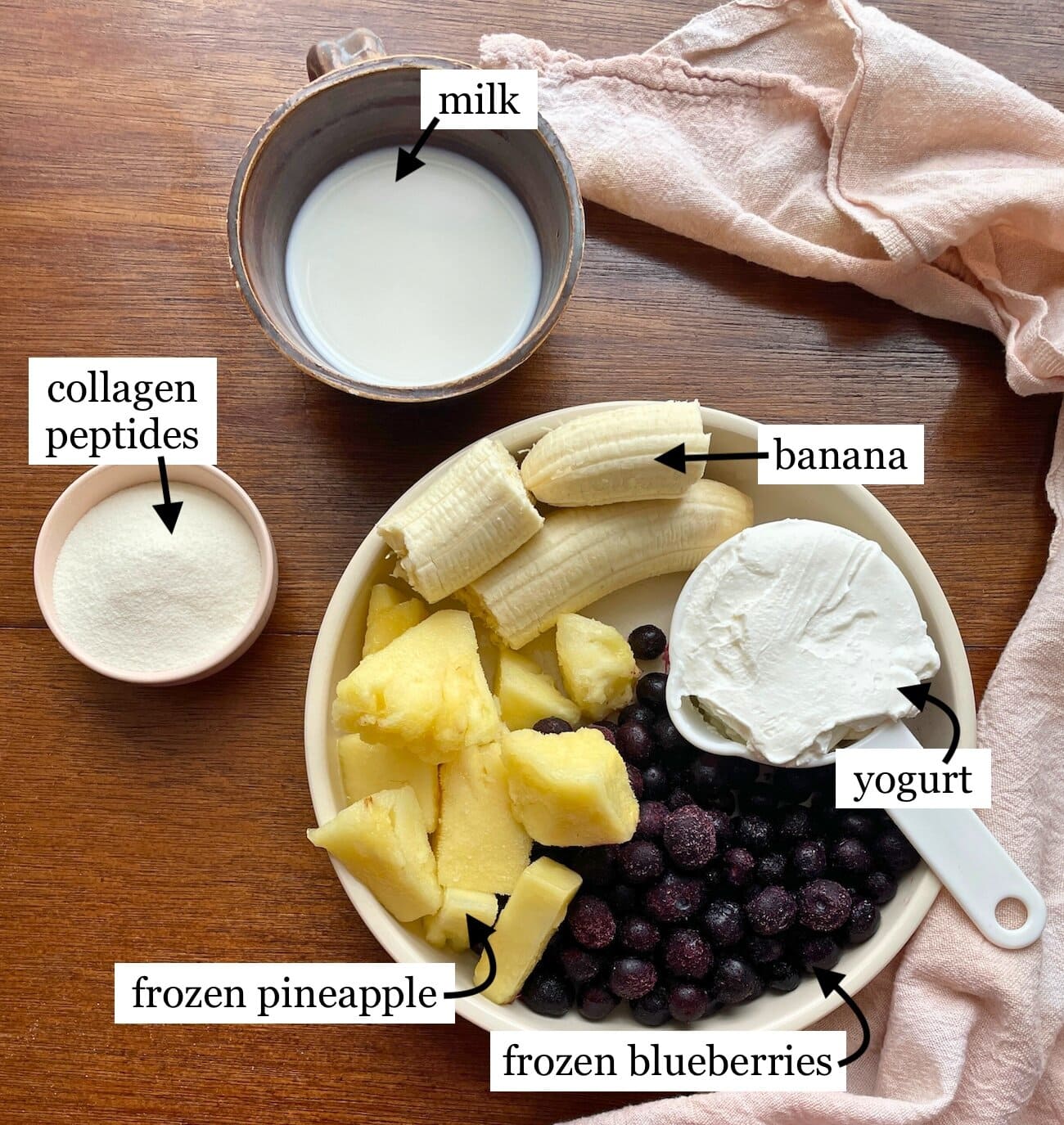 The ingredients needed to make blueberry pineapple and banana smoothie with yogurt, laid out and labeled.