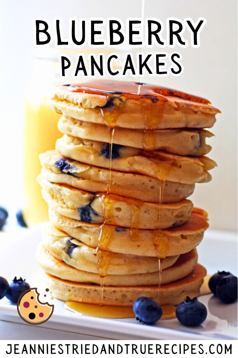 A pin image of a stack of fluffy blueberry pancakes with maple syrup dripping down the side and blueberries scattered around them.