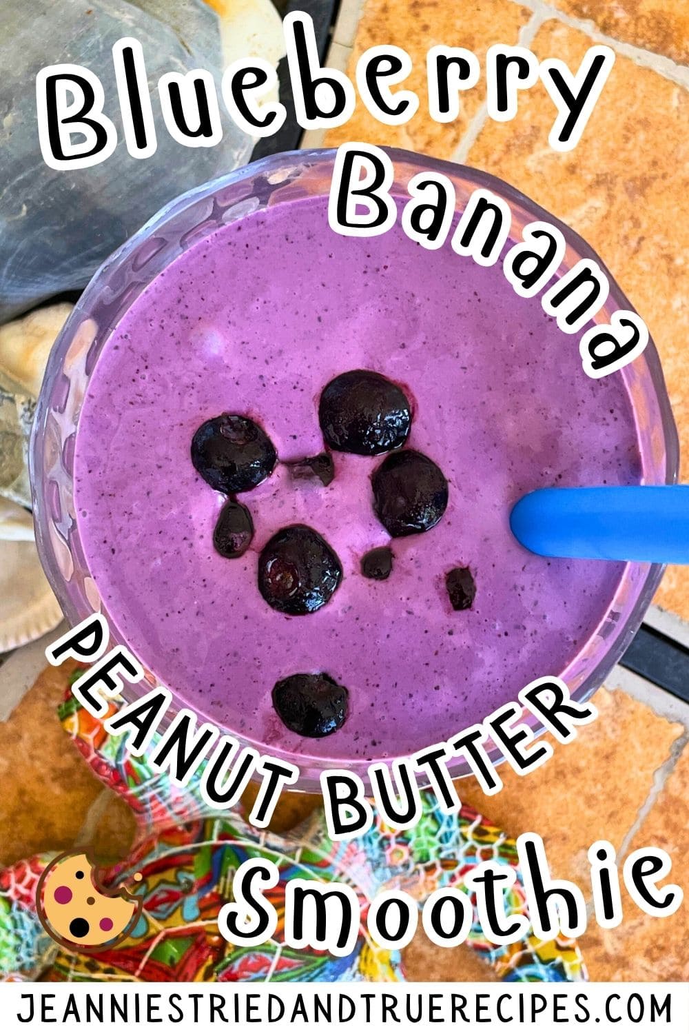 A pin image of a creamy, bluberry and banana smoothie with blueberries on top on a tiled background with a blue straw and a patterned turtle off to the side.